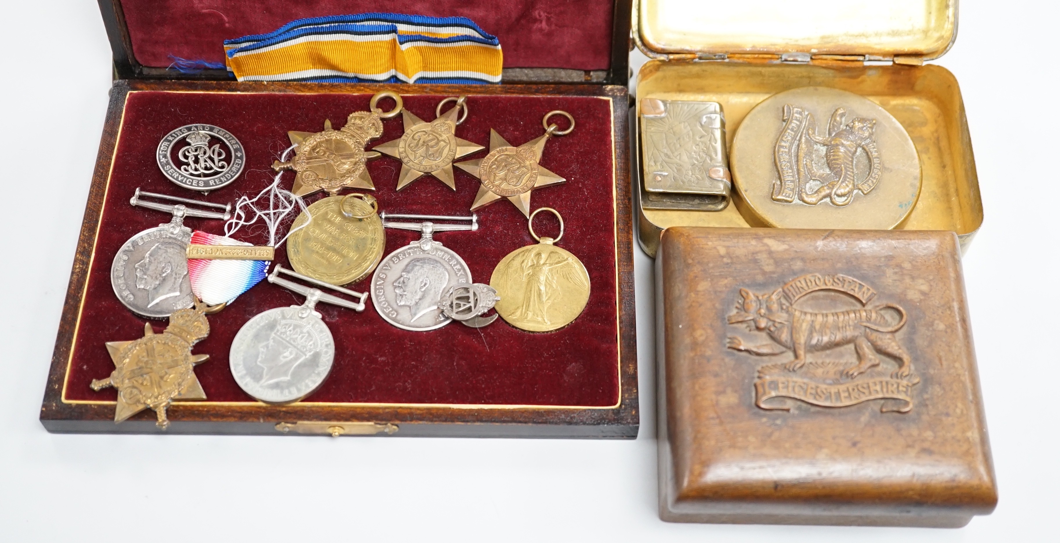 A quantity of war medals, Leicestershire brass paperweight, a carved box Somme Trench art match case and a gilt brass Christmas tin